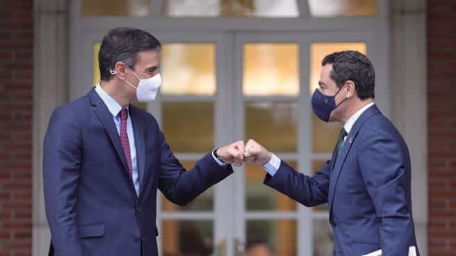 El presidente del Gobierno, Pedro Sánchez, saluda con el puño al presidente de la Junta de Andalucía, Juan Manuel Moreno Bonilla, a su llegada al Palacio de la Moncloa, el 17 de junio de 2021