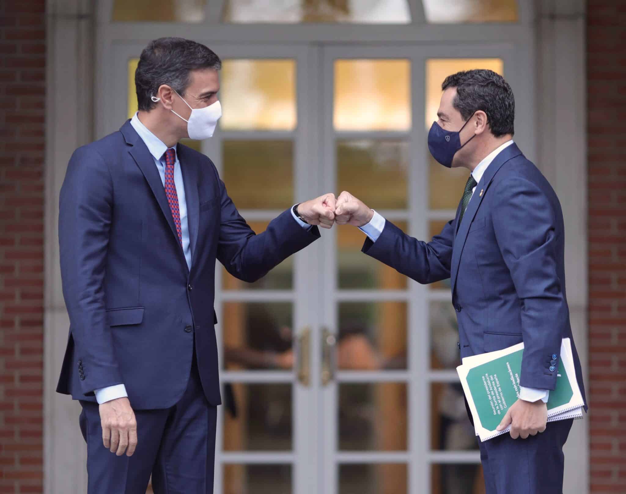 El presidente del Gobierno, Pedro Sánchez, saluda con el puño al presidente de la Junta de Andalucía, Juan Manuel Moreno Bonilla, a su llegada al Palacio de la Moncloa, el 17 de junio de 2021