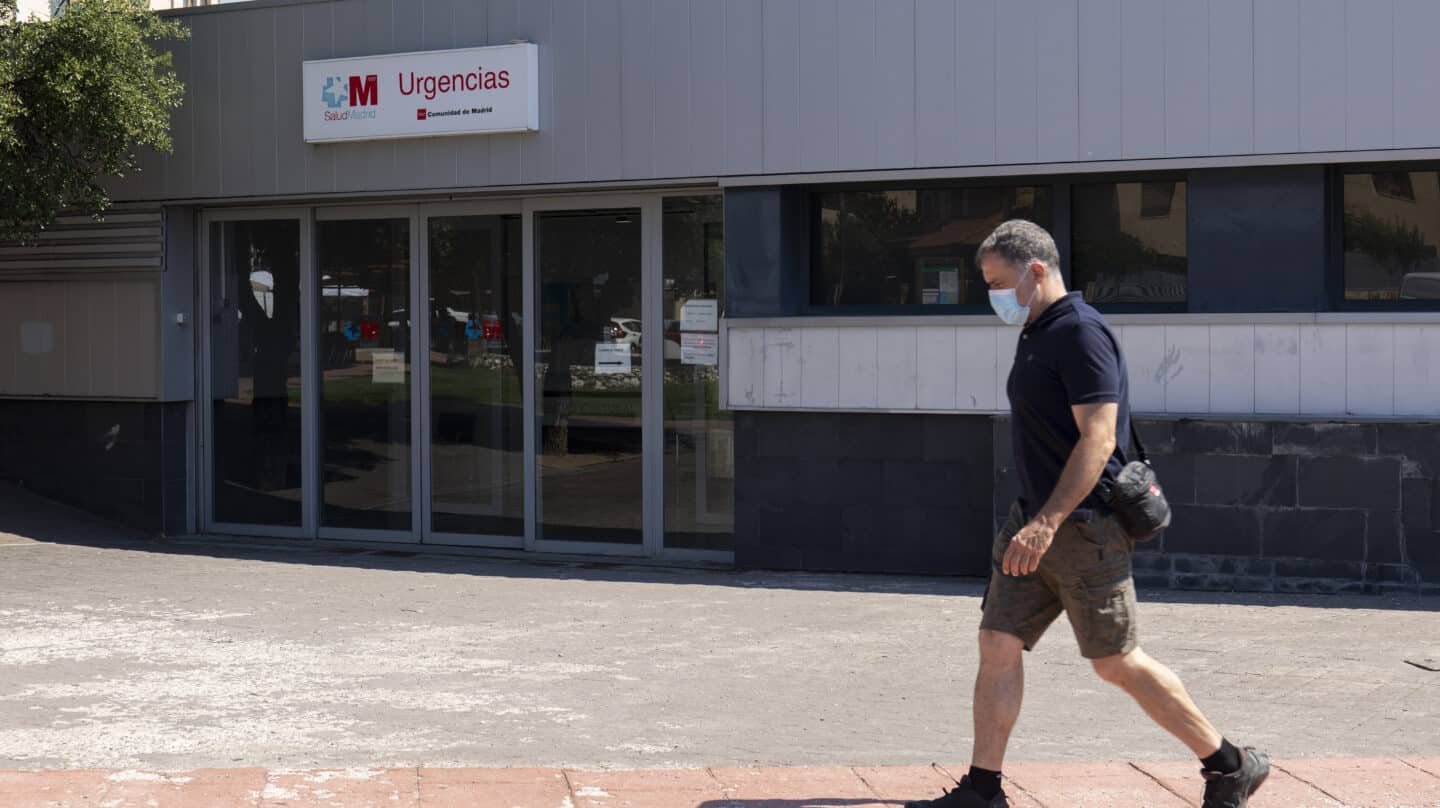 Un hombre pasea con mascarilla frente a unas Urgencias en Moralzarzal (Madrid).