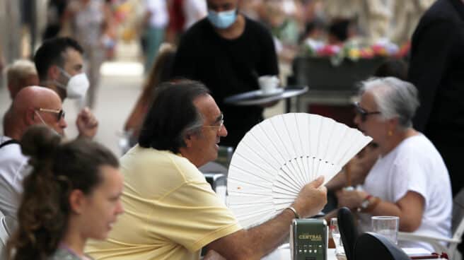 Un hombre se abanica en una terraza de Sevilla.