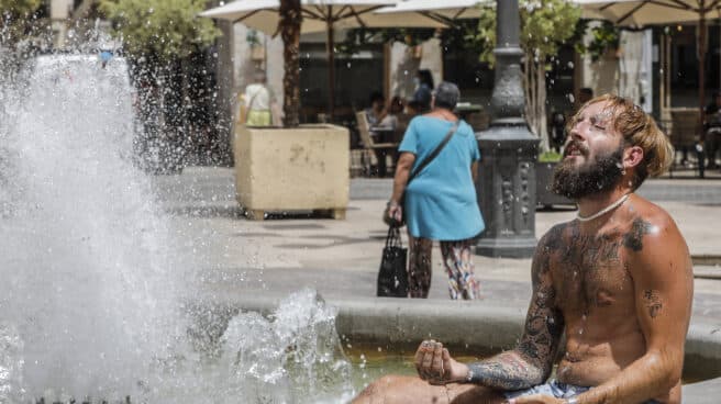 Alerta roja por calor en la Comunidad Valenciana y Murcia Un hombre se refresca en una fuente del centro de Valencia