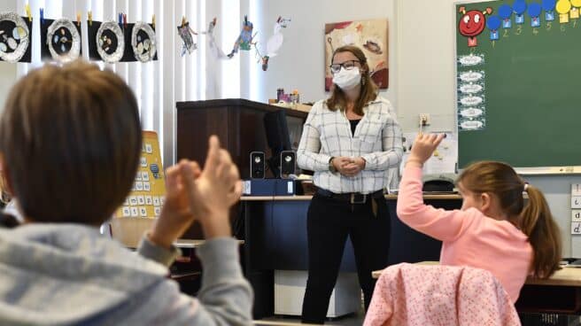 Una maestra en clase con alumnos de Infantil.