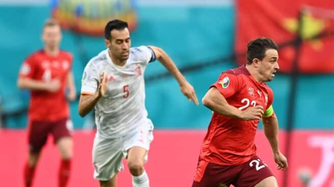 Busquets defiende a un jugador suiza, con una bandera de Vietnam en el fondo, durante los cuartos de final de la Eurocopa.