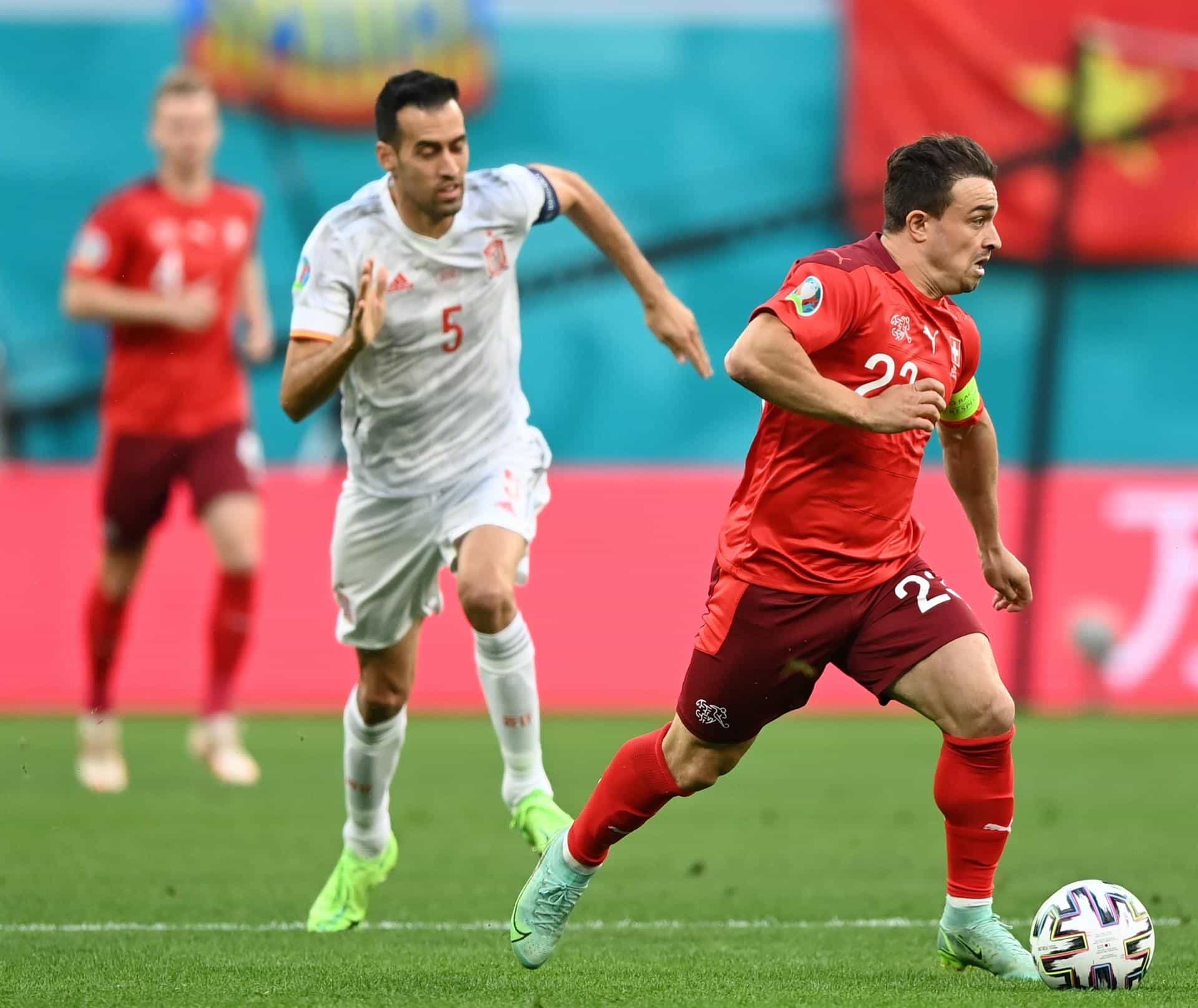Busquets defiende a un jugador suiza, con una bandera de Vietnam en el fondo, durante los cuartos de final de la Eurocopa.