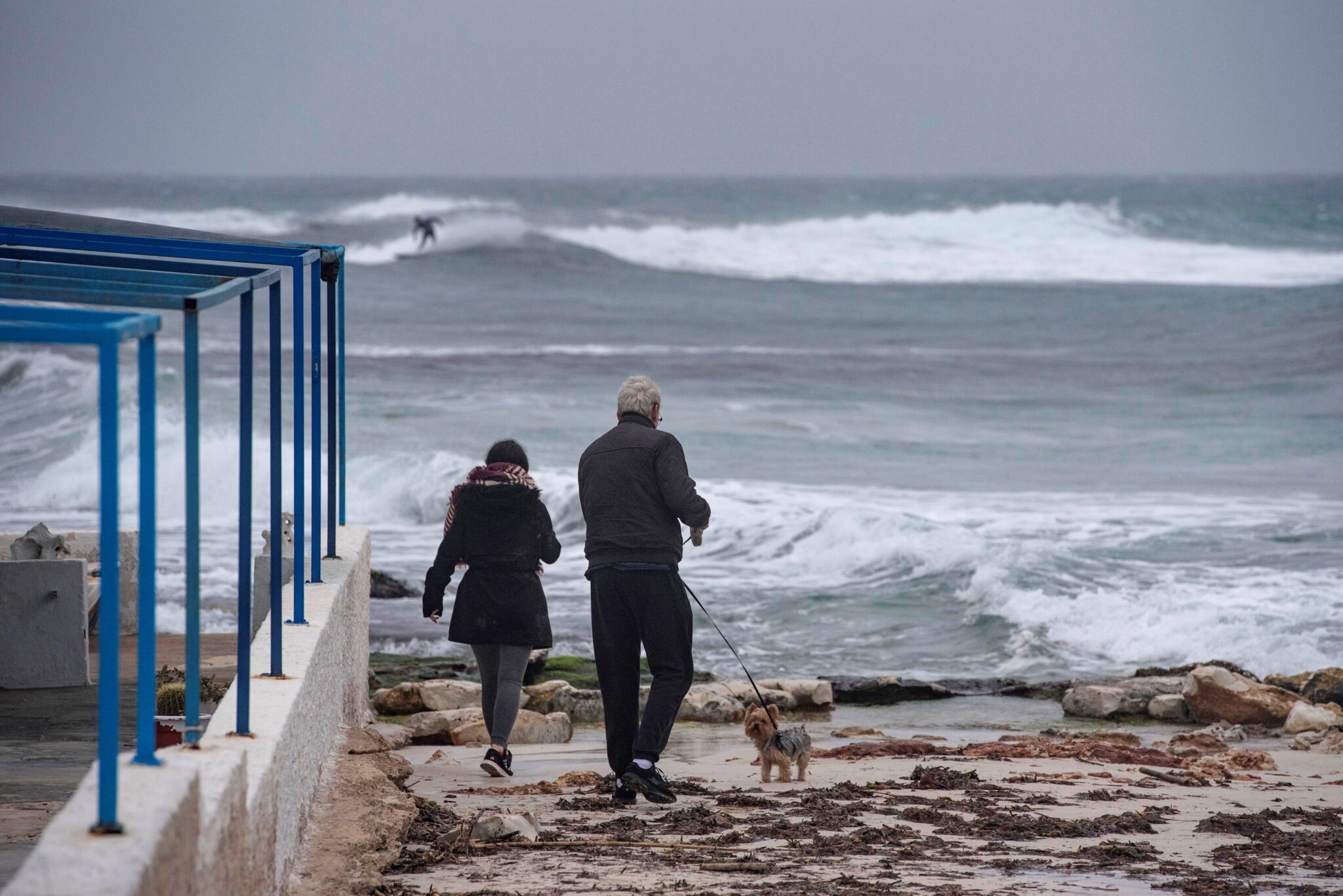 Dos personas caminan a la orilla de la costa de Biniancolla, en la isla de Menorca, en una imagen de archivo.