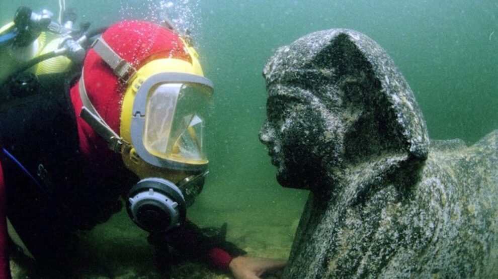 Un miembro del equipo, con una estatua hallada en Thonis-Heraclion