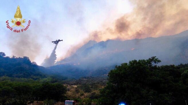 Los bomberos tratan de acabar con uno de los incendios de Sicilia.