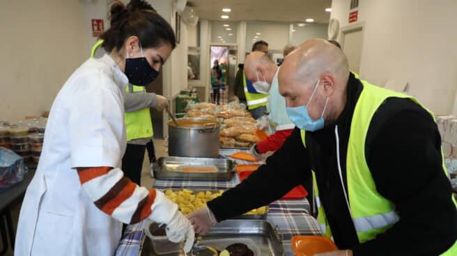La epidemia de coronavirus empeoró los datos del hambre en 2020 Una cocinera sirve comida varias raciones de comida a voluntarios
