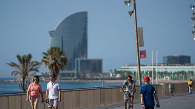 Una pareja pasea por la Barceloneta.