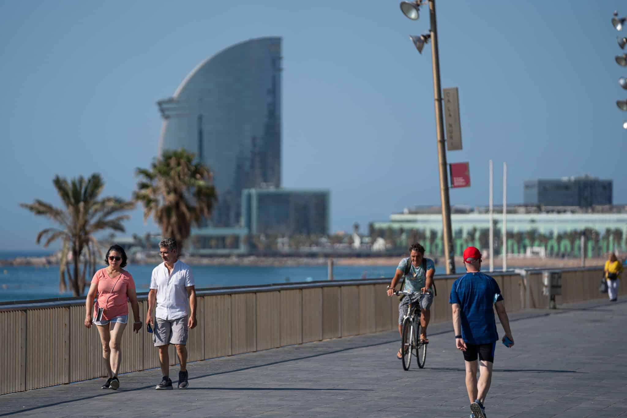 Una pareja pasea por la Barceloneta.