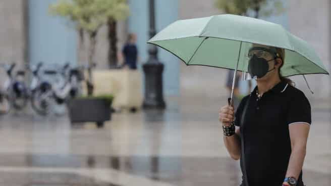 Una persona sostiene un paraguas mientras llueve