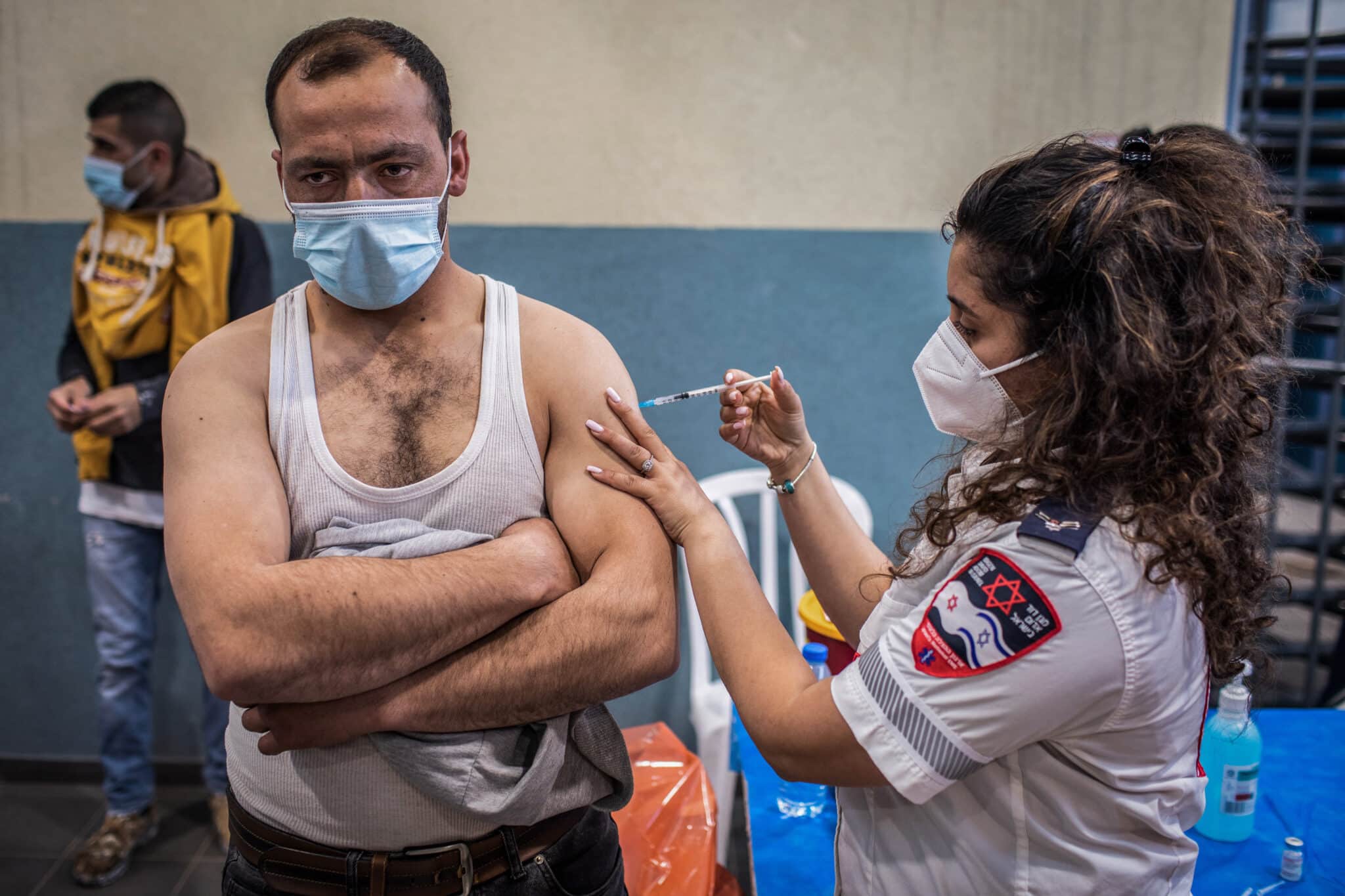 Un trabajador palestino con permiso de trabajo en Israel recibe una dosis de la vacuna contra el coronavirus