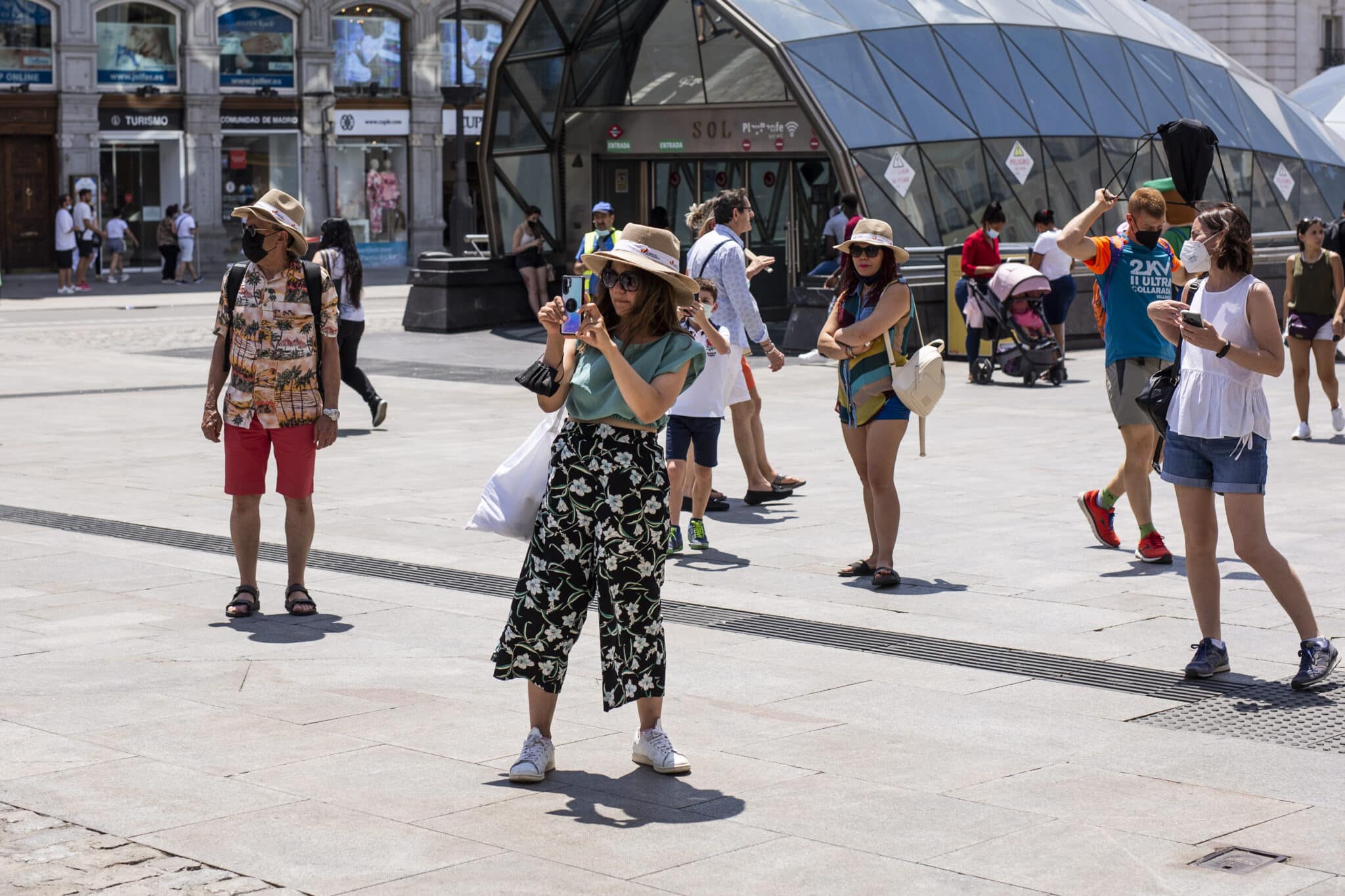 Una mujer toma una foto en la Puerta del Sol