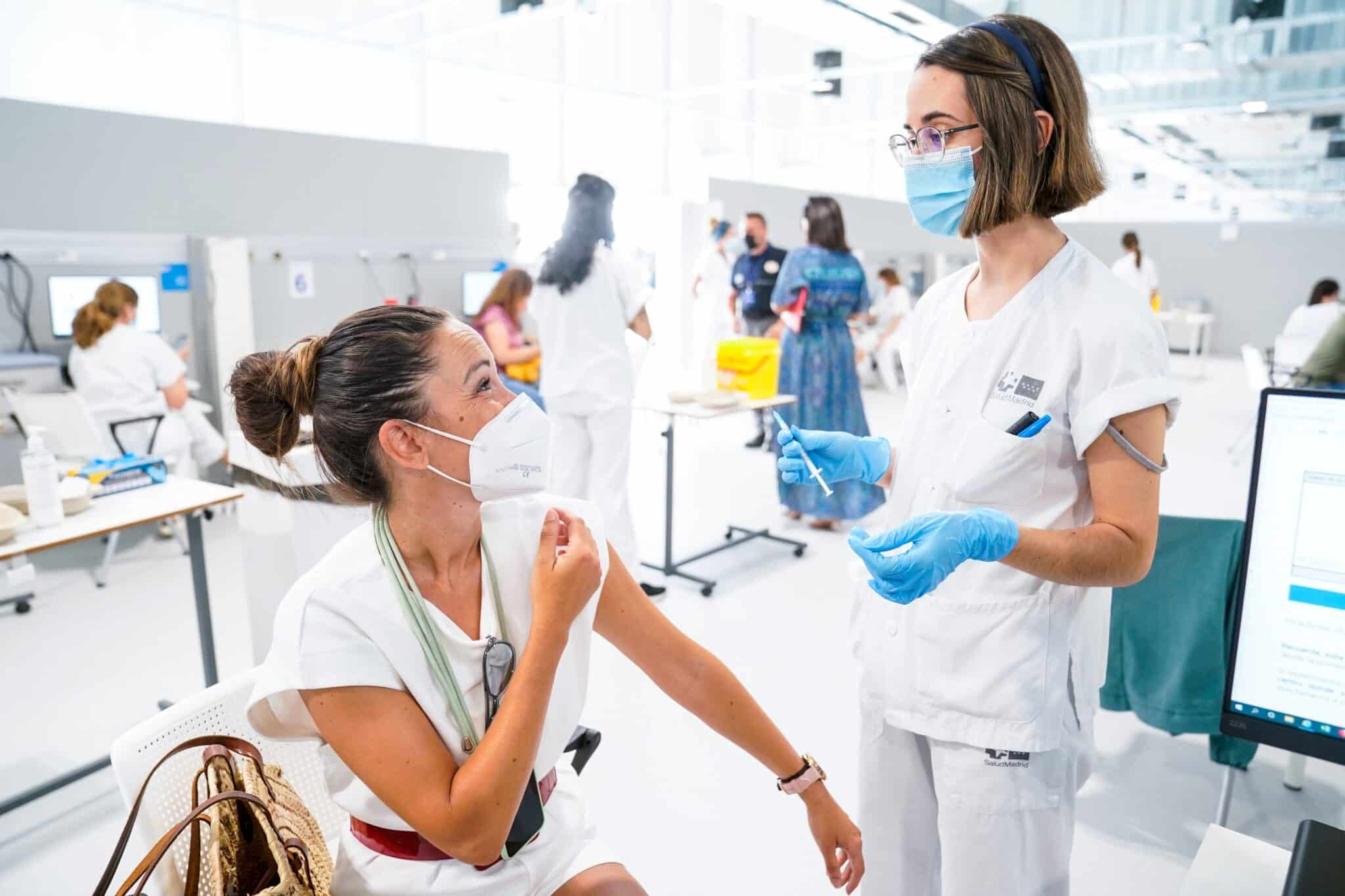 Una mujer conversa con una enfermera mientras le vacuna en el Hospital público de emergencias Enfermera Isabel Zendal