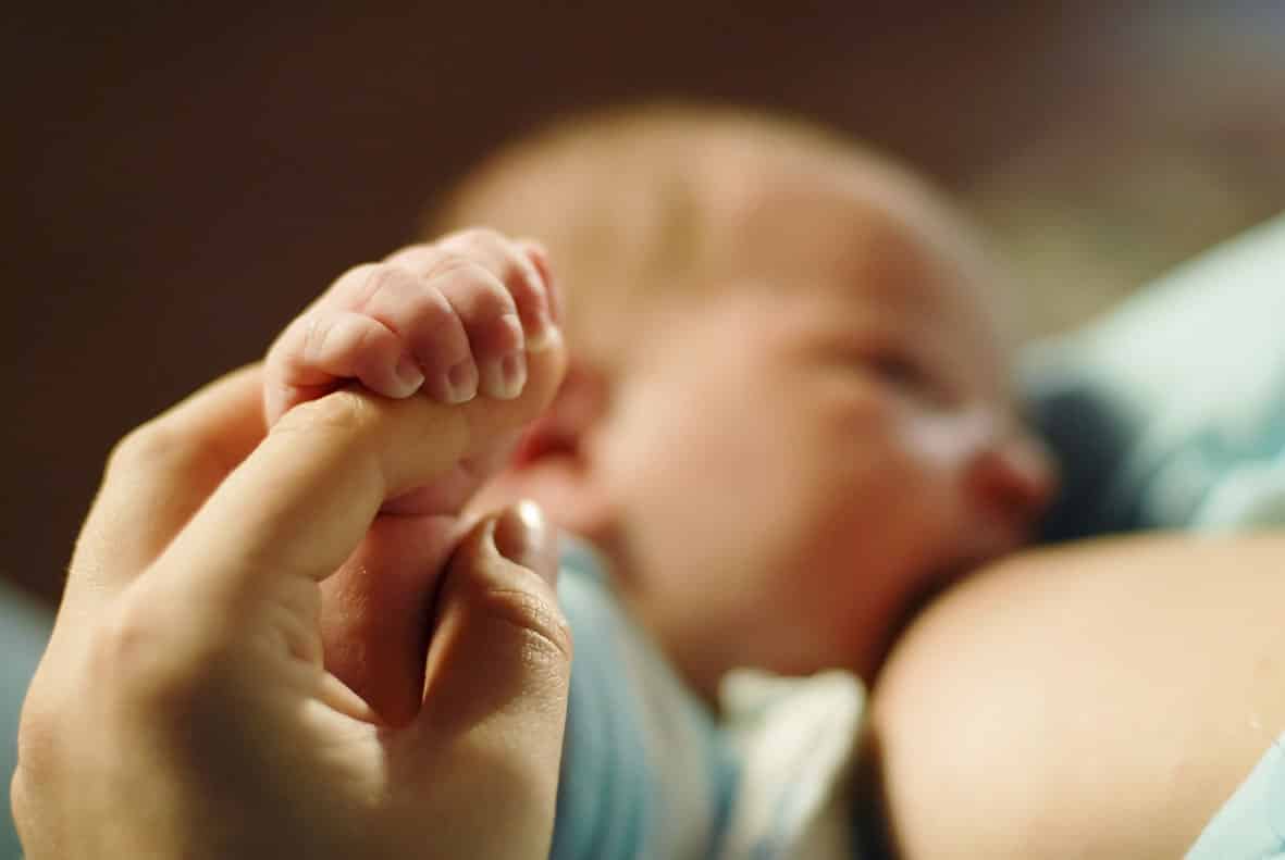 Una madre da de mamar a su bebé leche materna.