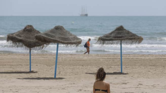 Una mujer toma el sol en la playa de Valencia