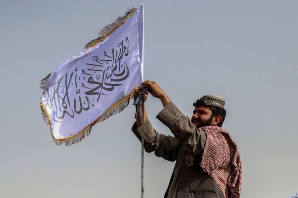 Un talibán coloca la nueva bandera de Afganistán en Kandahar
