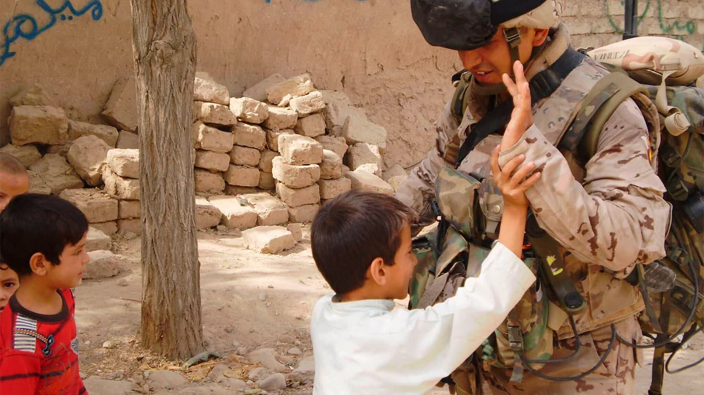 Unos niños juegan con un soldado español en Badghis, en 2010