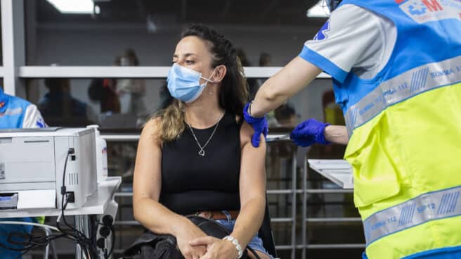 Un sanitario administra una dosis de la vacuna de Pfizer a una mujer en el Wizink Center de Madrid.