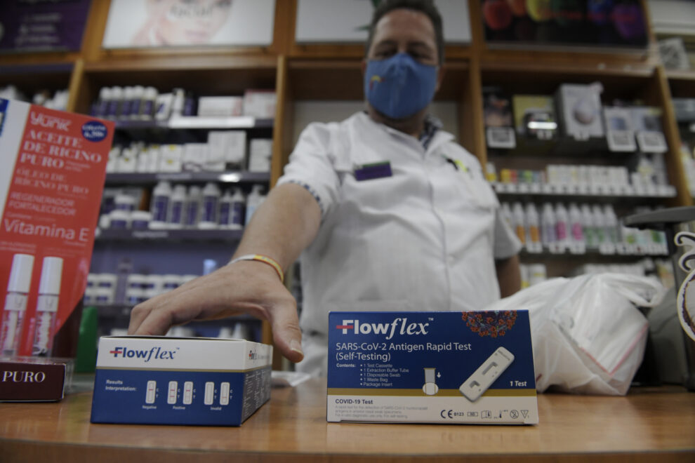 Un farmacéutico enseña un test de antígeno de farmacia.
