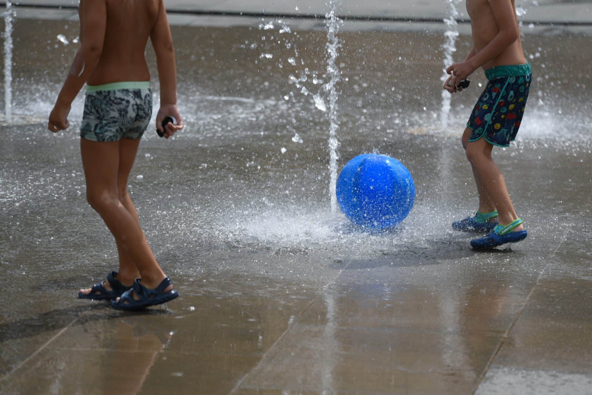 Dos niños juegan en una fuente del Parc Central, en Valencia.