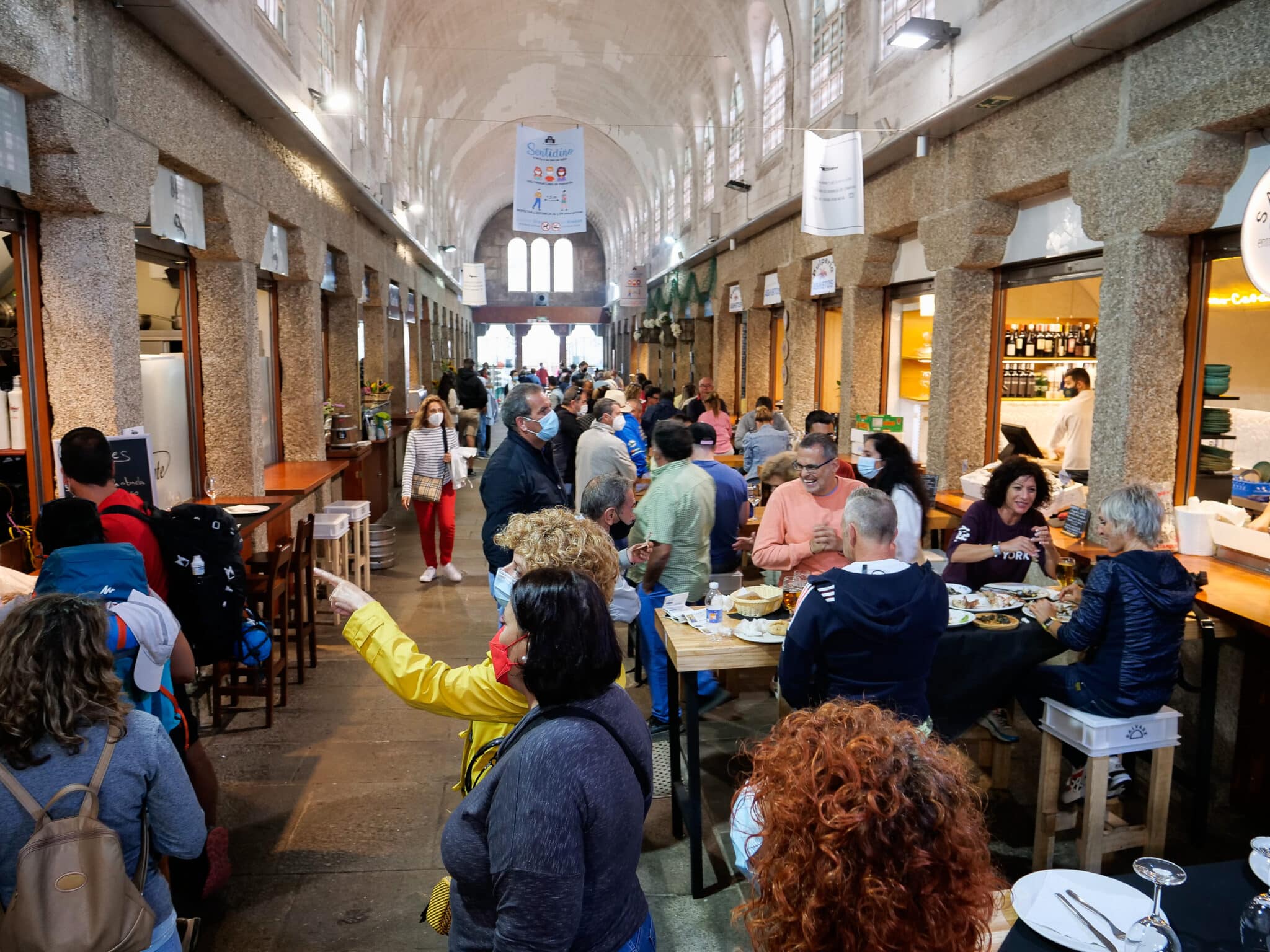 Varias personas acuden a un espacio con locales de hostelería en Santiago de Compostela, A Coruña.