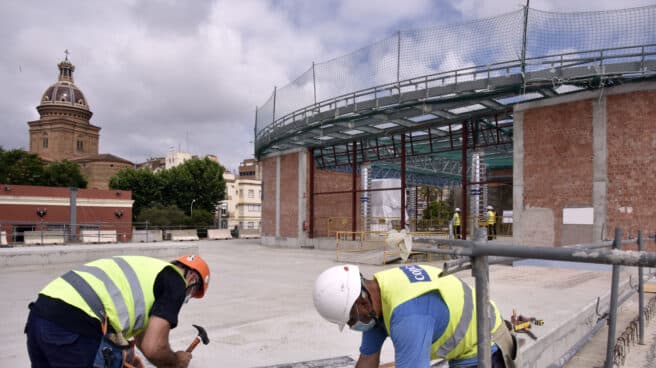 Dos obreros trabajan en las obras de construcción de la nueva estación subterránea de Sant Andreu Comt en Barcelona.