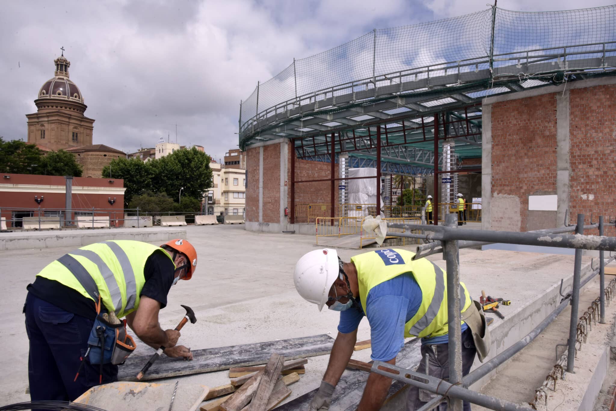 Dos obreros trabajan en las obras de construcción de la nueva estación subterránea de Sant Andreu Comt en Barcelona.