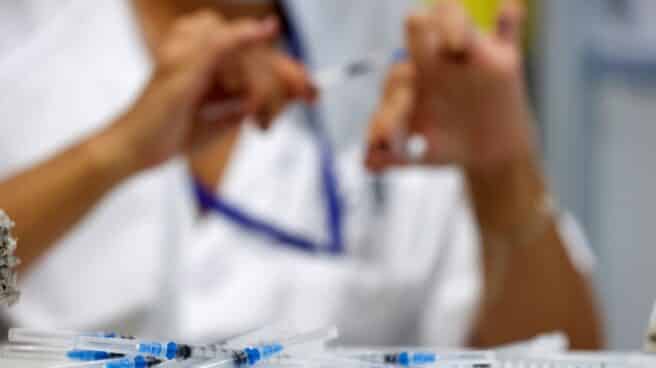 La incidencia sigue bajando y Sanidad registra un ligero repunte de las hospitalizaciones en Cataluña Una sanitaria prepara dosis de vacunas contra la covid-19 en el hospital Enfermera Isabel Zendal de Madrid