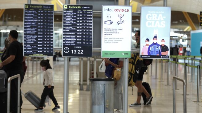Pasajeros cerca de paneles informativos en la terminal T4 del aeropuerto Adolfo Suárez Madrid-Barajas