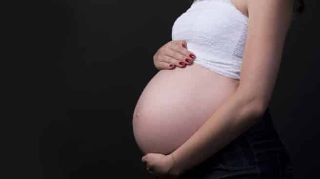 Una mujer embarazada se sostiene el vientre.
