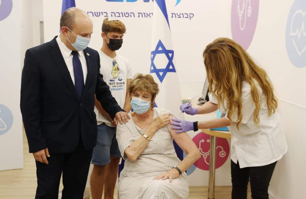 Naftali Bennett. primer ministro israelí, acompaña a su madre, Mirna Bennett a ponerse la tercera dosis de la vacuna.