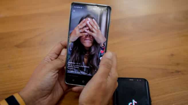 Una persona mira en su móvil el vídeo de una joven en la red musical Tik Tok
