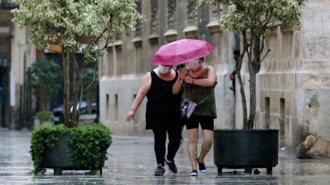 Dos personas caminan en una jornada marcada por las lluvias y la bajada de temperaturas.