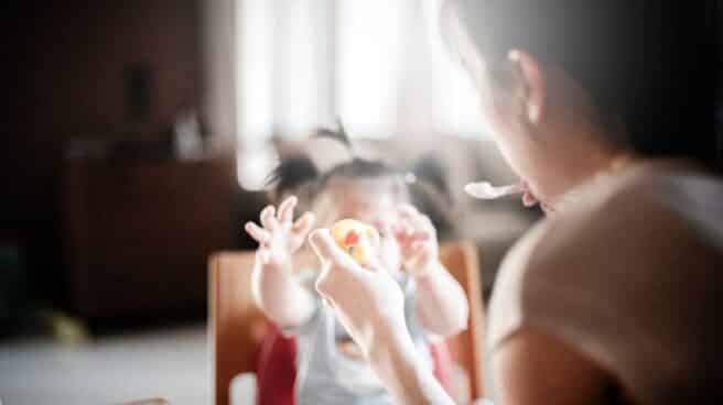 Una madre da de comer a un bebé.