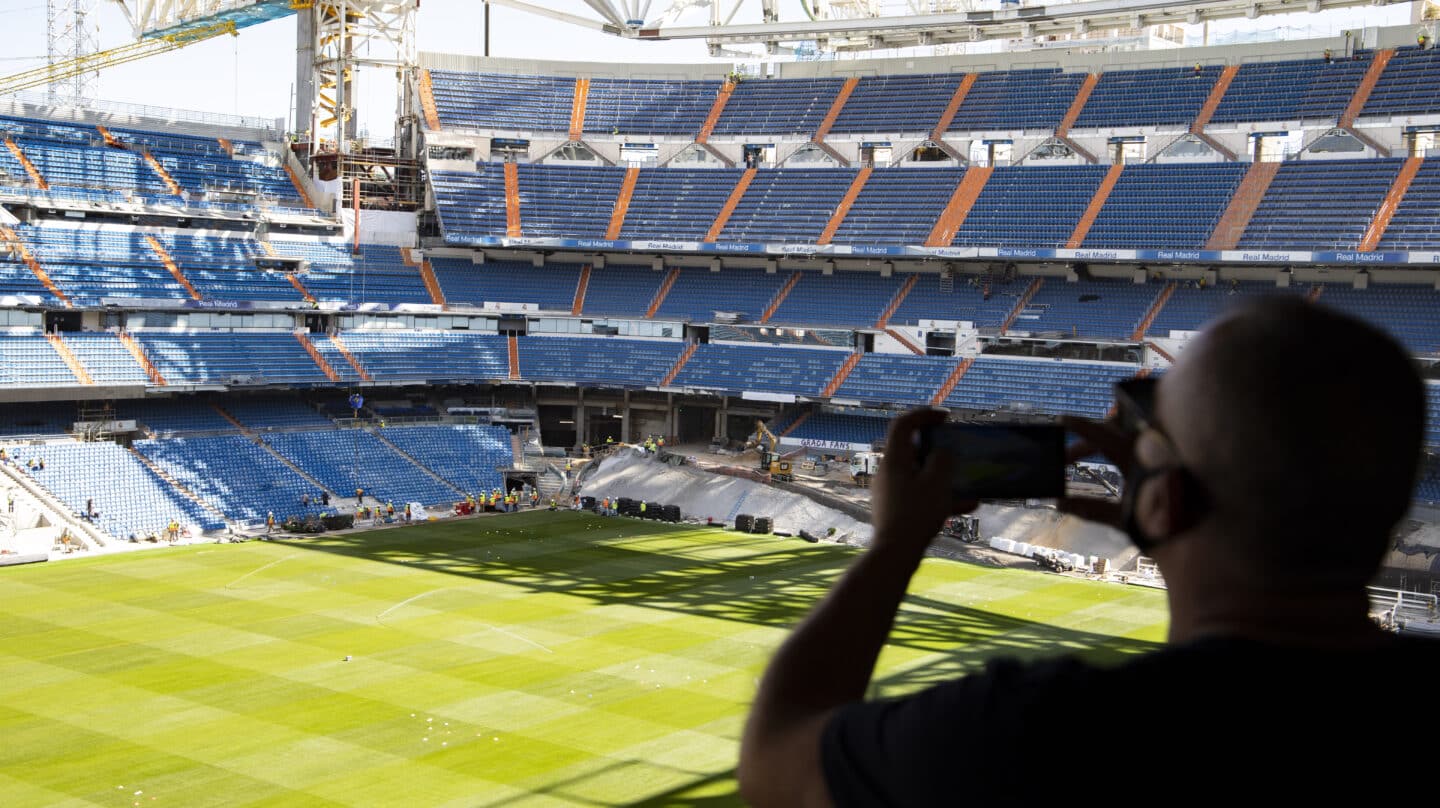 Un aficionado saca una fotografía desde la grada abierta al Tour del Bernabéu