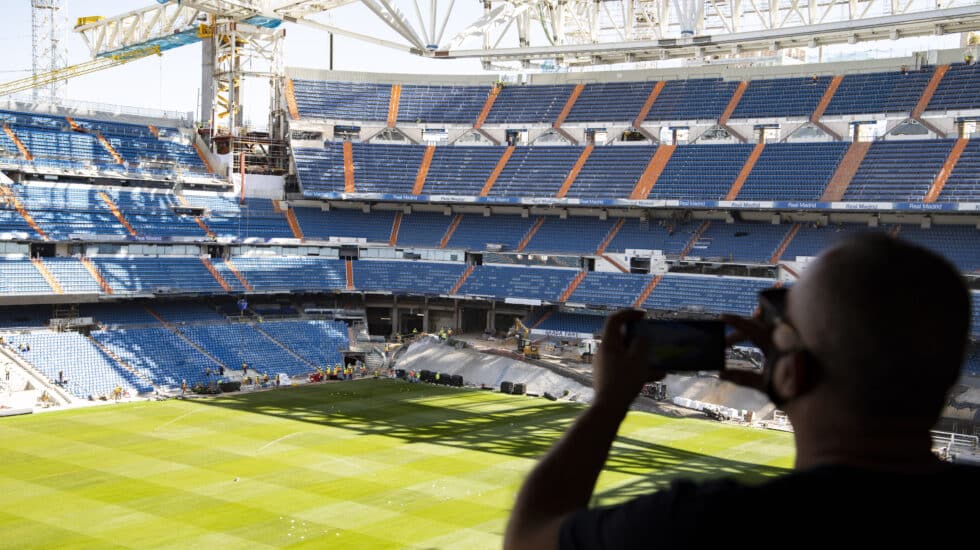 Un aficionado saca una fotografía desde la grada abierta al Tour del Bernabéu
