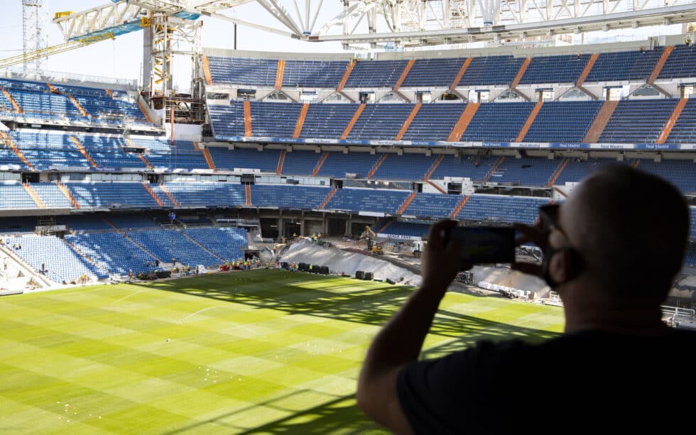 Un aficionado saca una fotografía desde la grada abierta al Tour del Bernabéu