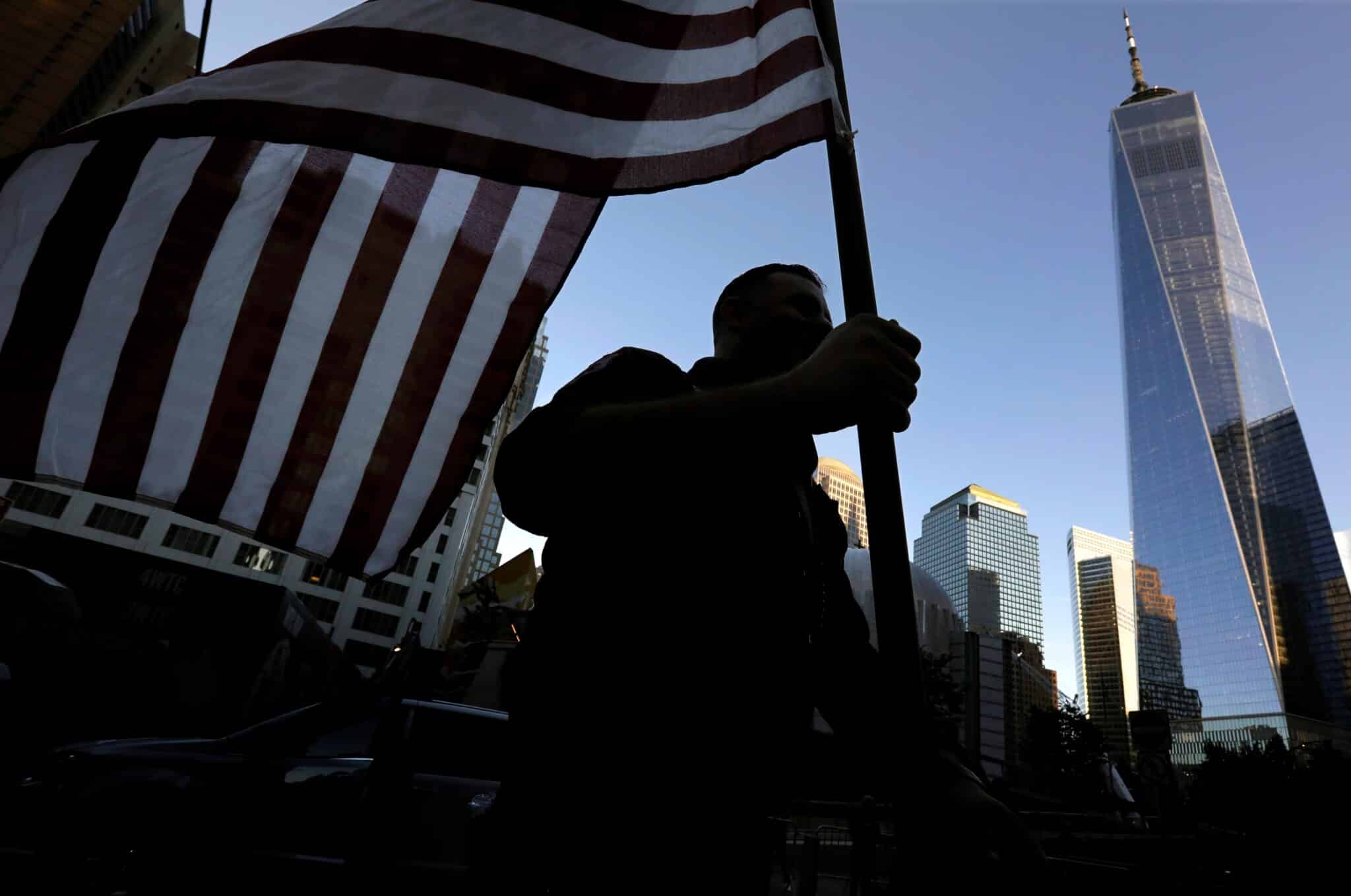 Un bombero porta una bandera de EEUU en los actos del vigésimo aniversario del 11-S