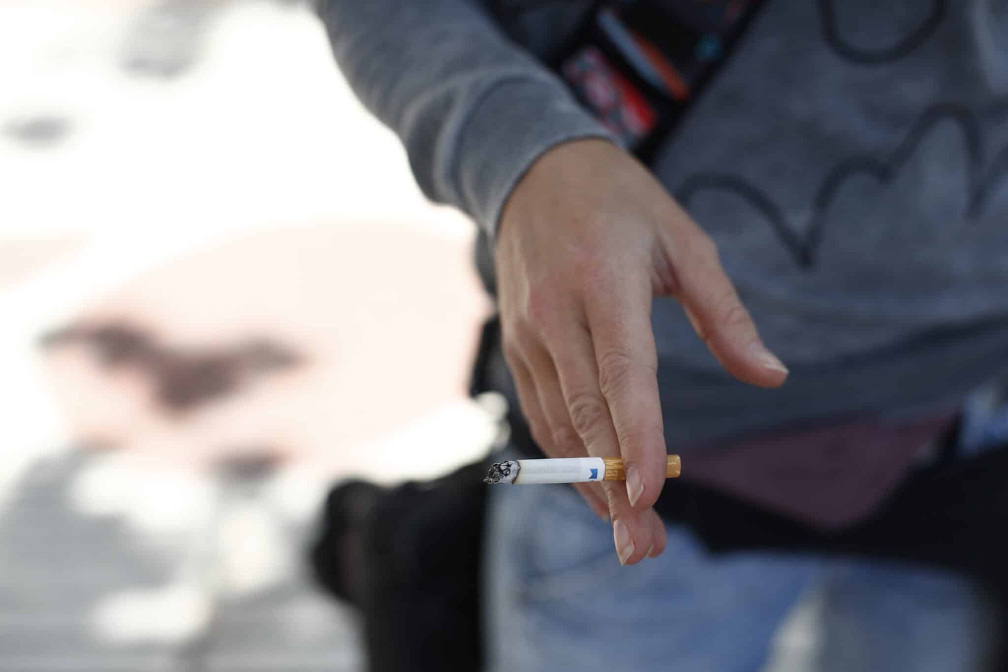Una persona con un cigarro en la mano.
