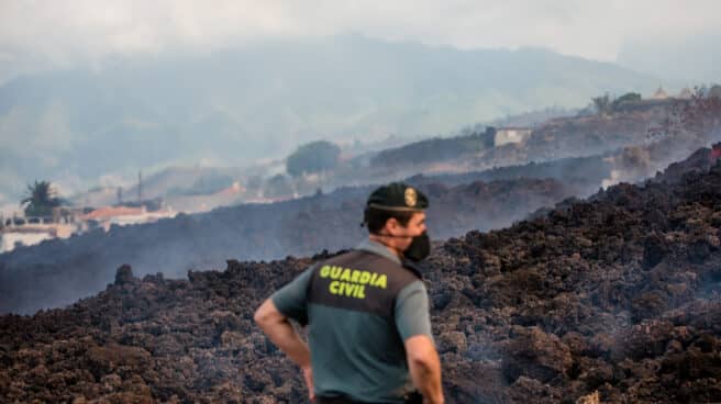 Un guardia civil vigila la lava del volcán de La Palma.