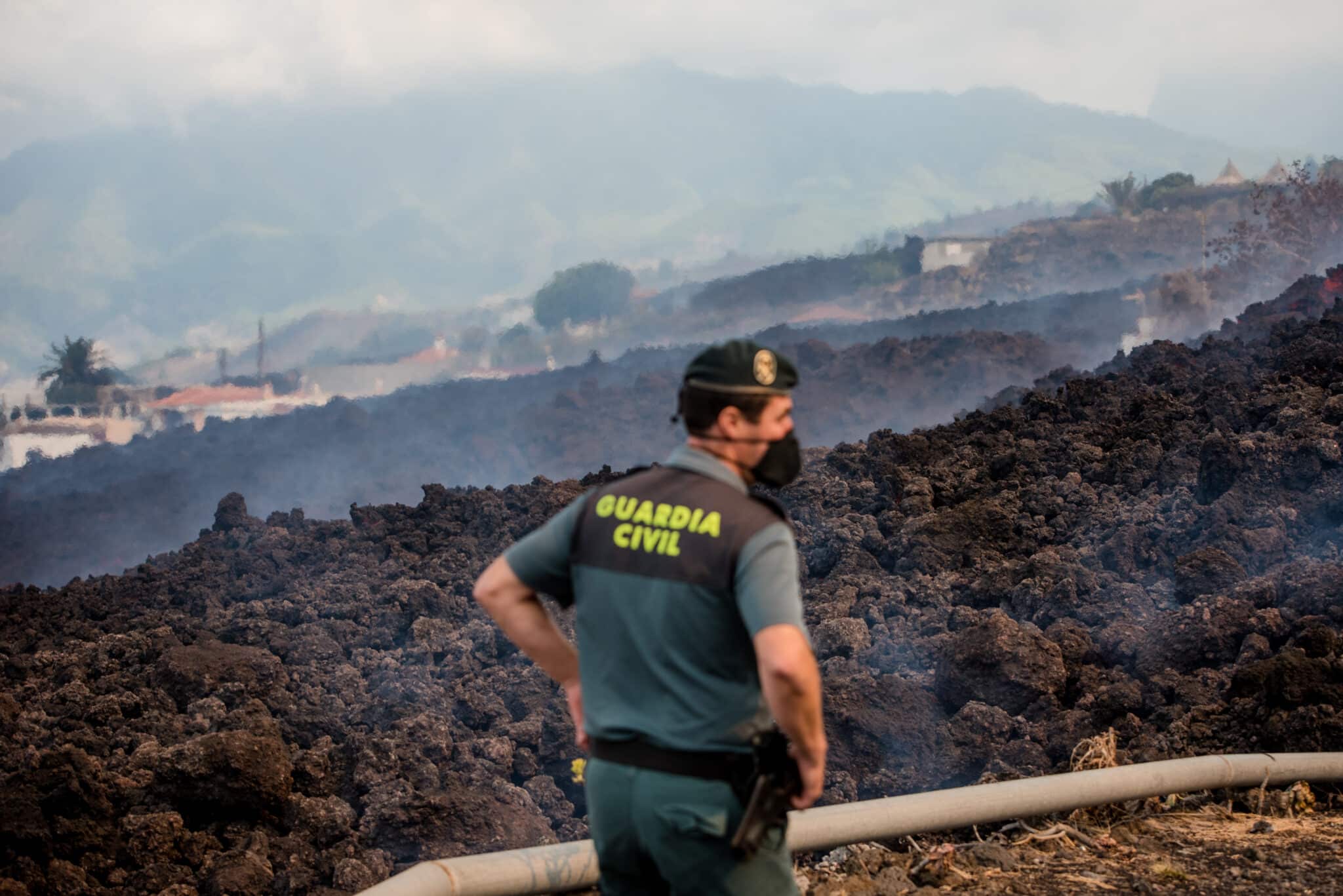 Un guardia civil vigila la lava del volcán de La Palma.