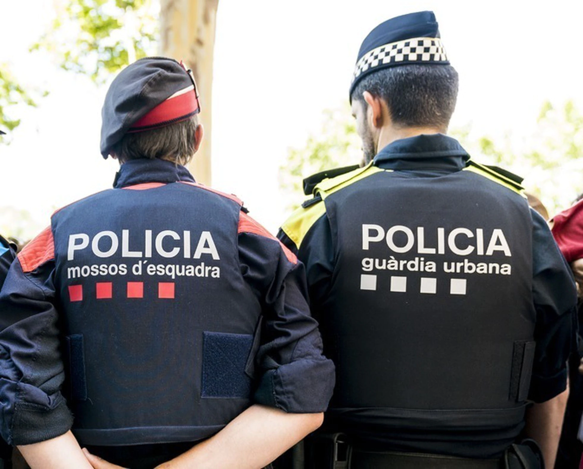 Chalecos por la parte trasera de la Policía Urbana y Los Mossos d'Esquadra