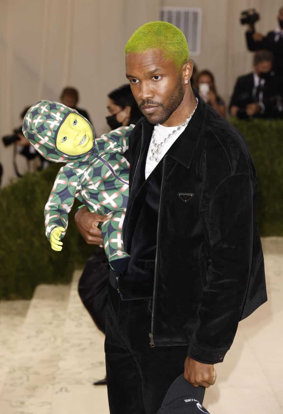 El cantante y compositor Frank Ocean sorprendió por su peculiar acompañante: un robot de un bebé verde, a juego con su teñido pelo