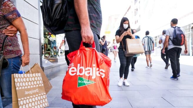 Un hombre sostiene varias bolsas en plenas rebajas de verano en Madrid.