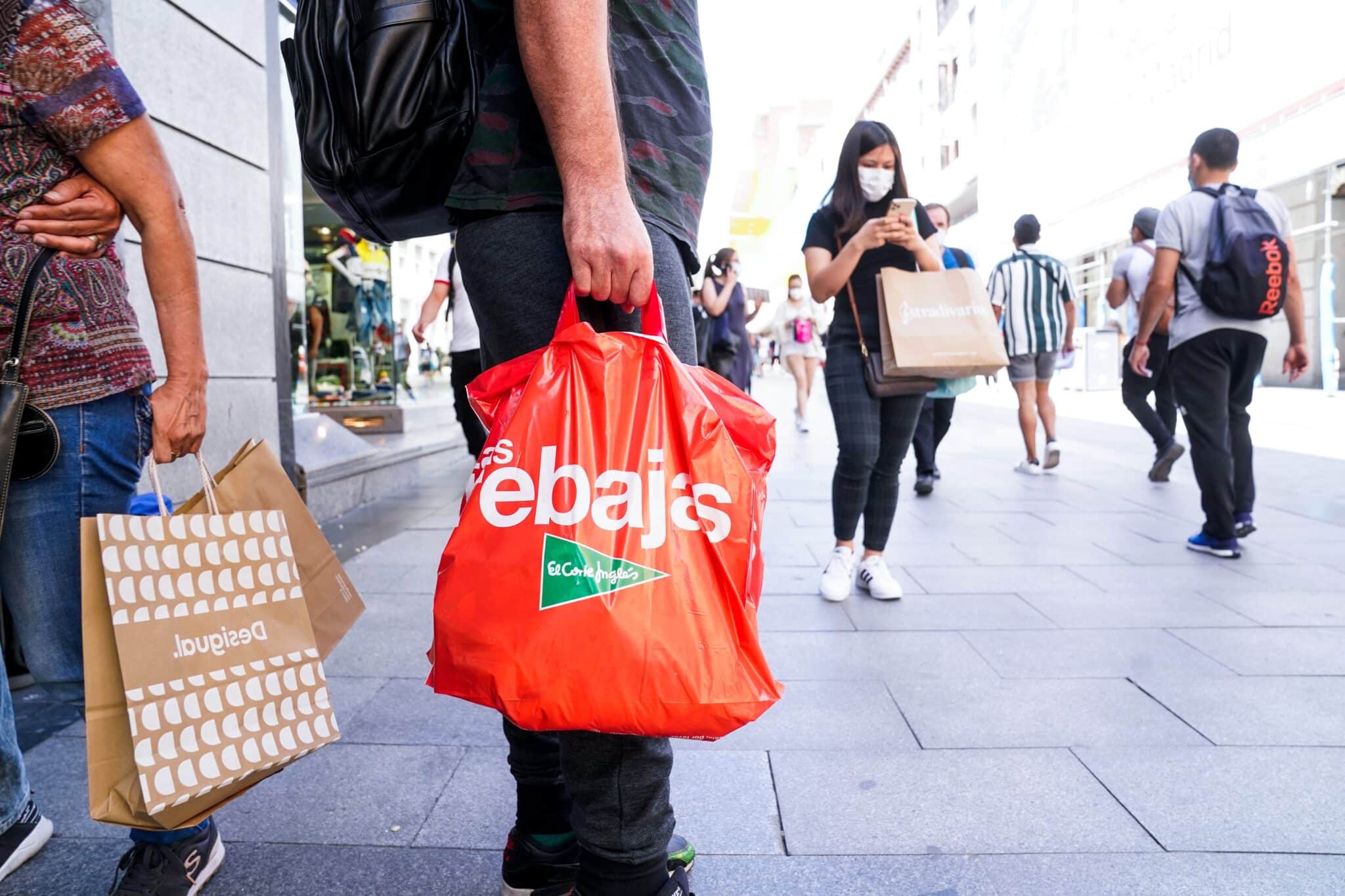 Un hombre sostiene varias bolsas en plenas rebajas de verano en Madrid.