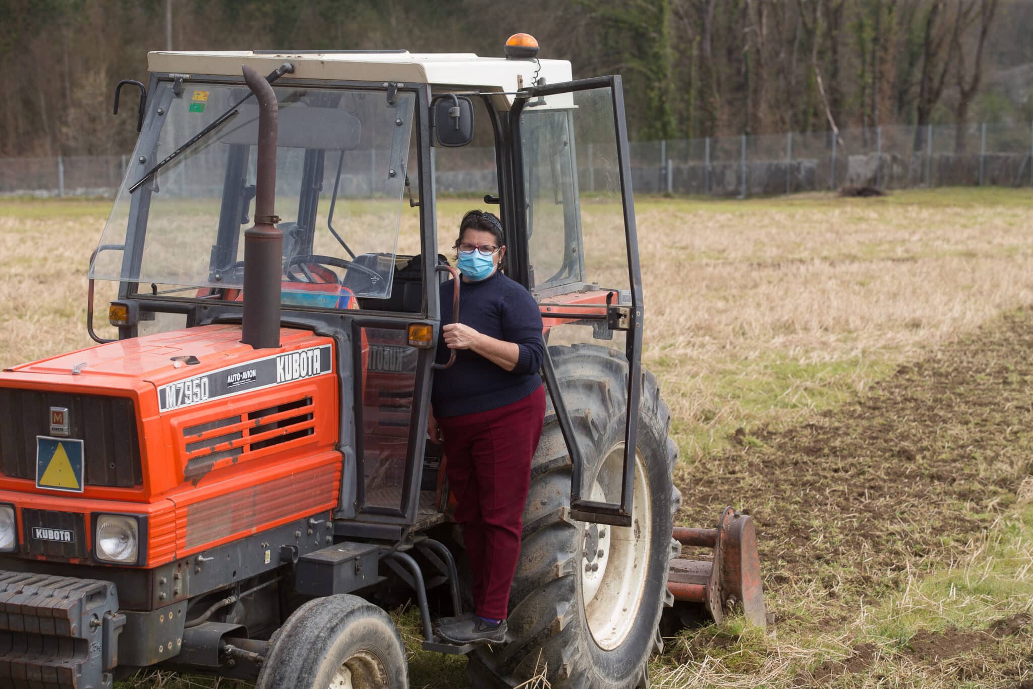 Una mujer, Lola Martínez ara con marcarilla en su tractor para plantar patatas en su finca de Chamoso, O Corgo, en Lugo, Galicia (España).
