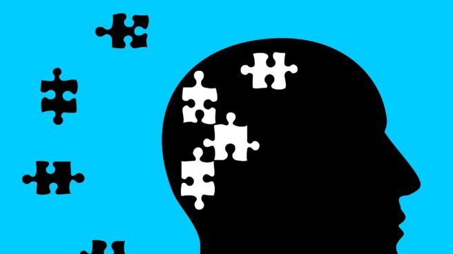 Ilustración de la silueta de la cabeza de perfil de un hombre sobre fondo azul con piezas de puzzle para referenciar las alteraciones que produce el Alzheimer