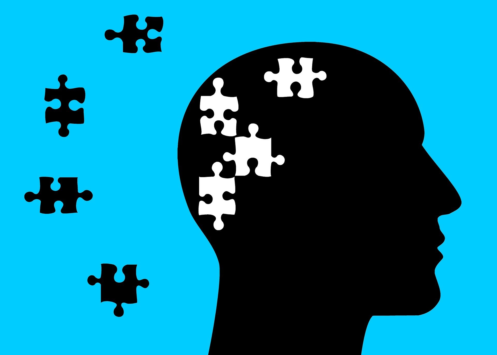 Ilustración de la silueta de la cabeza de perfil de un hombre sobre fondo azul con piezas de puzzle para referenciar las alteraciones que produce el Alzheimer