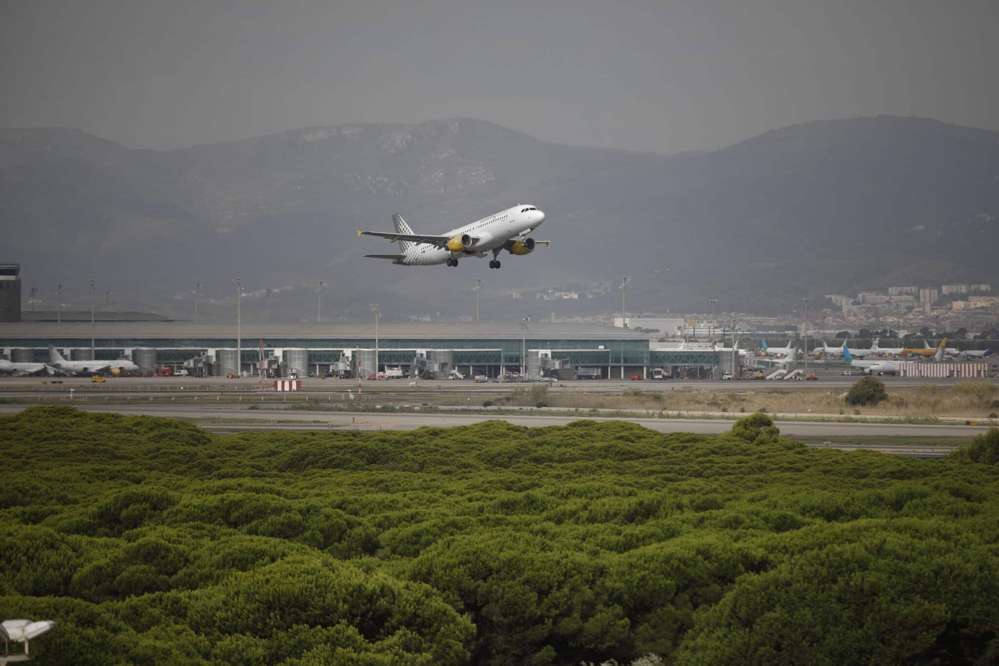 Un avión vuela por el espacio protegido de la Ricarda, en El Prat de Llobregat.